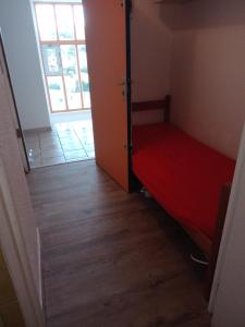 a small room with a red bed and a door at studio in Le Grau-du-Roi +14 photos
