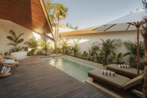 a swimming pool in the middle of a backyard with plants at Sage Villas Bingin in Uluwatu