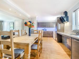 a kitchen and dining room with a wooden table and chairs at Still Waters in Hill Head