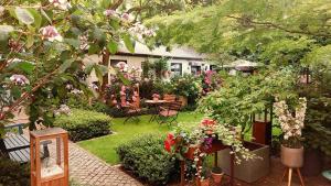 un jardín con mesa, sillas y flores en Gastehaus HH- Winterhude en Hamburgo