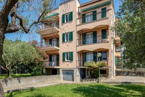 an apartment building in a park with a tree at Residence Mizar 2 in Pietra Ligure