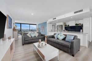 a living room with two couches and a table at Circle on Cavill Contemporary Luxury and Spacious Three Bedroom Apartment in Gold Coast