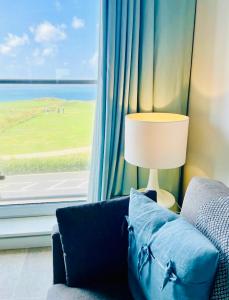 a living room with a blue couch and a window at Stunning Sea Views, luxury apartment beaches & restaurants are a short walk away in Newquay