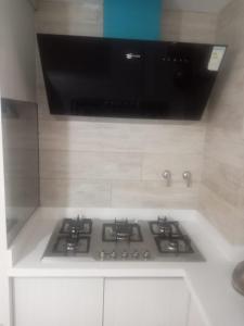 a kitchen with a stove with a tv above it at ALTOS DEL GUADALQUIVIR in Tarija