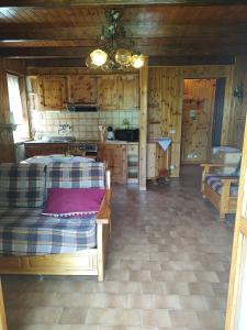 a room with two beds and a kitchen with wooden walls at MONTAGNA CHE PASSIONE in Chiomonte