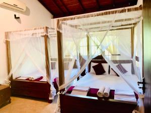 a bedroom with two bunk beds with mosquito nets at Sinhagiri Villa in Sigiriya