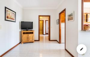 a living room with a tv on a wooden cabinet at Amorosa Viana do Castelo in Viana do Castelo