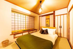 a bedroom with a bed and a window at The OASIS in Sapporo