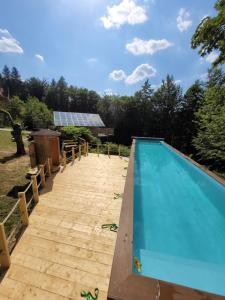 a swimming pool with a wooden walkway around it at Cicha Polana in Szczyrk