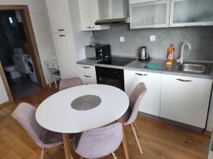 a small kitchen with a white table and chairs at Veranda in Saborsko +16 photos