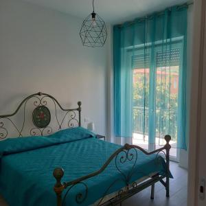 una camera con letto e finestra con tende blu di Il Sorriso Di Anna a Montesilvano
