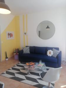 un salon avec un canapé bleu et une table en verre dans l'établissement Appartement Avignon Centre ville intra muros, à Avignon