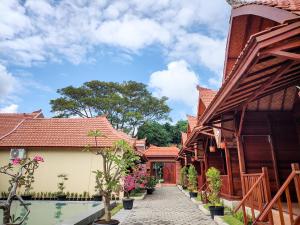 a walkway between two buildings with flowers in pots at Uli Wood Villa, Jimbaran BALI - near GWK in Jimbaran