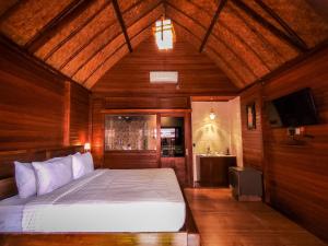 een slaapkamer met een bed en een tv. bij Uli Wood Villa, Jimbaran BALI - near GWK in Jimbaran