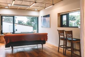 a bedroom with a bed and two chairs at Stay JungEui in Seogwipo