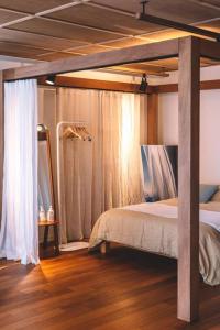 a bedroom with a canopy bed and a wooden floor at Stay JungEui in Seogwipo