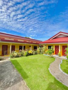 a house with a lawn in front of it at Uptown Guesthouse in Siquijor