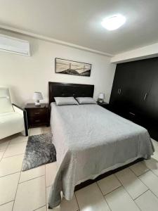 1 dormitorio con 1 cama grande y 2 mesitas de noche en Modern Condo in Ecovivienda en Tegucigalpa