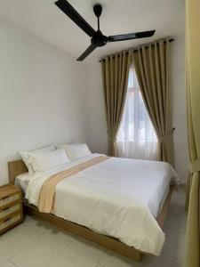 een slaapkamer met een bed en een plafondventilator bij Rumatepi in Melaka