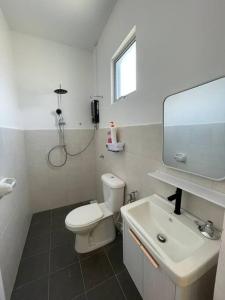 een witte badkamer met een toilet en een wastafel bij Rumatepi in Melaka