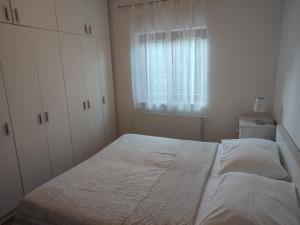 um quarto com uma cama grande e uma janela em Apartment Stipić em Zadar