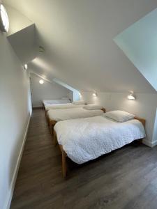 a row of four beds in a room at Auberge de jeunesse HI Millau La Maladrerie in Millau