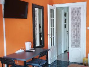 a dining room with orange walls and a table and chairs at Céline in Genoa
