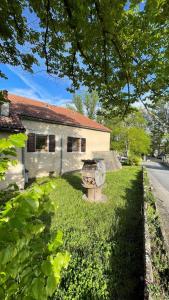 a house with a grill in front of a yard at Auberge de jeunesse HI Millau La Maladrerie in Millau