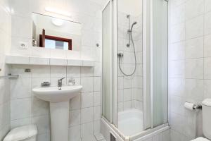 a white bathroom with a sink and a shower at Penzion Navara in Kolín