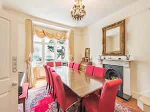 a dining room with a table and red chairs at The Cottage in St Margarets at Cliff