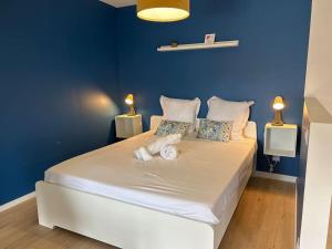 a blue bedroom with a large bed with towels on it at Le Studio 202 in Jasseron