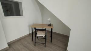 a small table with a chair and a lamp on it at Castella Aquae II Amplio loft para dos in Merida