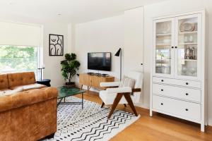 a living room with a couch and a tv at The Copenhagen Place - Enchanting 2BDR Flat with Balcony in London