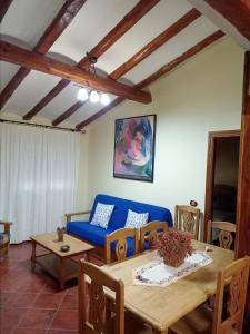 salon ze stołem i niebieską kanapą w obiekcie El Rincon Del Tajo w mieście Peralejos de las Truchas