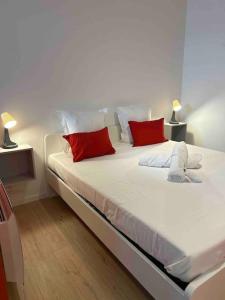 1 cama blanca grande con almohadas rojas en una habitación en Le 203 studio cosy, en Jasseron