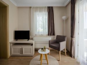 uma sala de estar com uma cadeira e uma televisão em Lovely Villa in Debeljak with Heated Private Pool em Debeljak