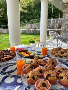 einen Tisch mit Muffins, Obst und Orangensaft in der Unterkunft B&B Relais sul Siroto in Castelnuovo Cilento