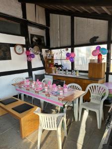une salle à manger avec une table, des chaises et des ballons dans l'établissement FeWo im Reit- und Ponyparadies Roos, à Halle