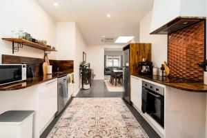 a kitchen with white walls and a rug on the floor at Convent Franklin - Alice Catherine Unit in Franklin