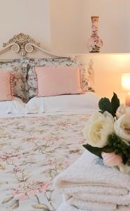 Una cama con sábanas rosas y blancas y flores. en Serendipity cottage, en Castleton