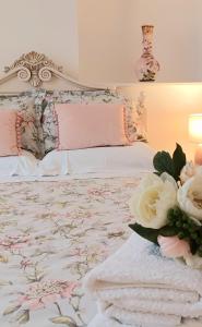 un letto con lenzuola e fiori rosa e bianchi di Serendipity cottage a Castleton