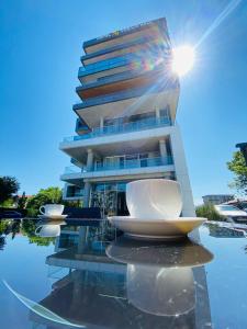a building with a reflection in a body of water at Hotel Nobilis Hall in K'obulet'i