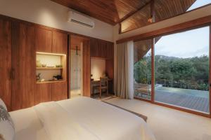 a bedroom with a bed and a large window at Sage Villas Bingin in Uluwatu +42 photos