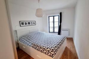 um quarto com uma cama num quarto branco em Elégant P4 du centre historique em Nîmes