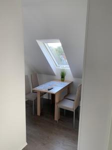 a dining room with a table and chairs and a window at Villa Mariensiel II in Sande