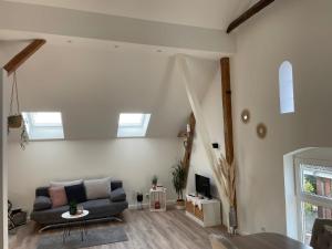 a living room with a couch and a tv at Stilvolle Ferienwohnung bei Bad Segeberg in Blunk