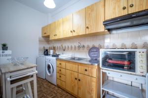 a kitchen with wooden cabinets and a washer and dryer at Casa de Stella in Limenas +28 photos