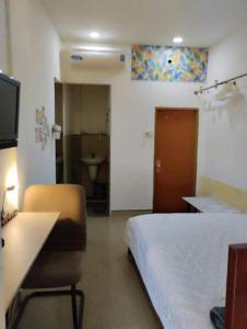 una camera d'albergo con letto, scrivania e bagno di Dragon homestay centre city Bitexco view room ad Ho Chi Minh