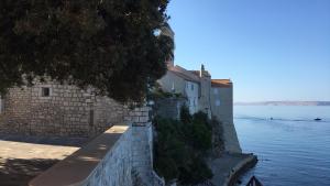 a building on the side of a body of water at Arbe Downtown in Rab
