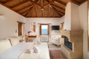 a living room with a bed and a fireplace at Bastione Malvasia Hotel (ex New Malvasia) in Monemvasia